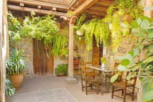 a patio with a table and chairs and plants at Casa Emblemática La Pileta Bentejui in Agüimes
