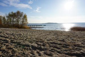 a sandy beach with a pier in the water at Apartment Schlossterrassen 4b in Pouch +6 photos