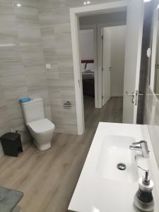 a bathroom with a white toilet and a sink at Casa do Carapacho in Luz