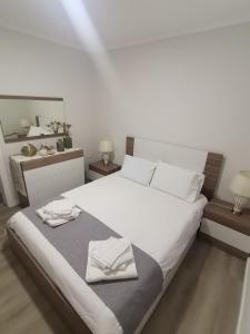 a bedroom with a white bed with two towels on it at Casa do Carapacho in Luz