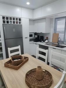 a kitchen with a wooden table with baskets on it at Casa do Carapacho in Luz