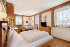 a hotel room with a bed and a dining room at Untersinnerhof Gsies in Valle Di Casies