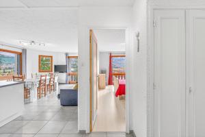 a kitchen and a living room with white walls at Le Ciel Plein in Embrun