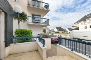 a apartment building with a blue railing and a street at Studio Emma in Le Croisic