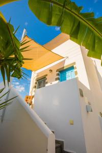 a white house with an umbrella and a white refrigerator at Pico Bello Patmos 12 in Patmos