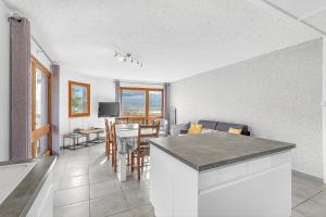 a kitchen and living room with a table and chairs at Le Ciel Plein in Embrun