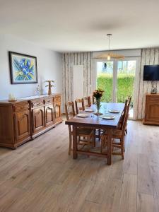 a dining room with a wooden table and chairs at Gîte Cadet Rousselle in Lessay