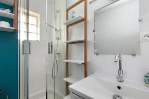 a bathroom with a shower and a sink and a mirror at Studio Emma in Le Croisic +14 photos