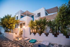 a white house with a fence and some plants at Pico Bello Patmos 12 in Patmos