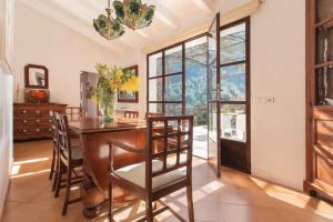a dining room with a table and chairs and a large window at Can Garí in Sóller