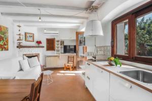 a kitchen and living room with white walls and wooden floors at Can Garí in Sóller