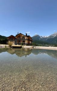 a house sitting on top of a body of water at Arnica Alpin Lodge 1 in Cavedago