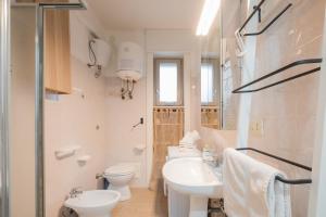 a white bathroom with a sink and a toilet at Rossini 14 Centro e Mare a Piedi in Porto Cesareo +26 photos