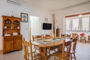 a dining room with a wooden table and chairs at Rossini 14 Centro e Mare a Piedi in Porto Cesareo