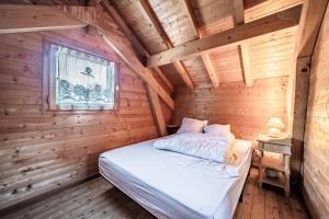a bedroom in a log cabin with a bed at Chalet 6p Classique - Les Biches in Verchaix