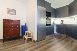 a kitchen with a stainless steel refrigerator and a wooden stool at Apartment Acapulco 6 in Fuengirola