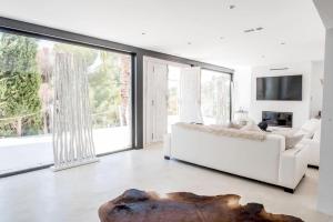 a living room with a white couch and large windows at Villa La Vida in Cala Llonga