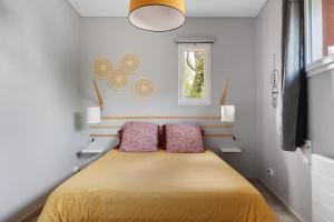 a bedroom with a bed with two pillows on it at A L'orée D'angers - Terra Botanica in Avrillé