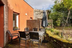 a table and chairs and an umbrella on a deck at A L'orée D'angers - Terra Botanica in Avrillé