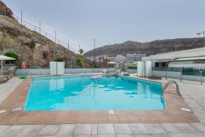 a large swimming pool with blue water at Eucalipto-Sun guaranteed-pool wifi in Puerto Rico de Gran Canaria