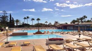 a large swimming pool with lounge chairs and a resort at Monterojo San Agustin Las Burras in San Agustin