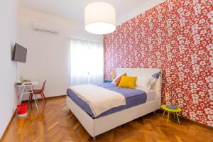 a bedroom with a bed and a red wall at Villa Vetrano in Cimitile