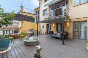 an outdoor patio with a couch and an umbrella at Kel Domènech Luxury Apartment in Besalú