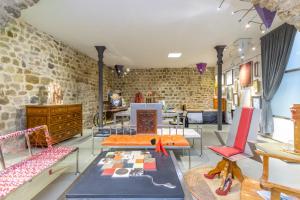 a room with tables and chairs and a brick wall at Kel Domènech Luxury Apartment in Besalú