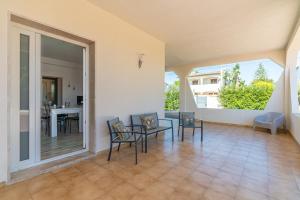 a large living room with chairs and a table at Villa Fontane Bianche with pool in Fontane Bianche