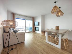 a living room with a table and chairs and a dining room at Primera linea Sant Antoni Calonge in Sant Antoni de Calonge