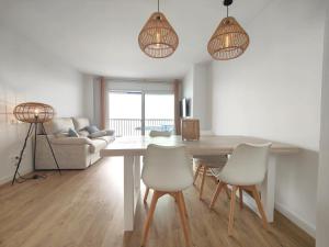 a living room with a dining room table and chairs at Primera linea Sant Antoni Calonge in Sant Antoni de Calonge