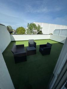 a balcony with three chairs on a roof at Appart 2 morangis in Morangis