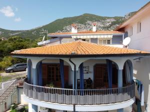 a house with a balcony with a mountain in the background at B&B Relax Gonone in Cala Gonone