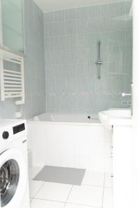 a bathroom with a washing machine and a sink at Appart 2 morangis in Morangis +11 photos