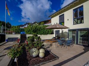 a patio with a table and chairs and an umbrella at Ferienwohnung Zur Quelle in Plettenberg