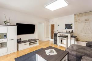 a living room with a couch and a tv at Ferienwohnung Zur Quelle in Plettenberg