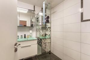 a bathroom with a glass shower and white walls at Ferienwohnung Zur Quelle in Plettenberg +16 photos