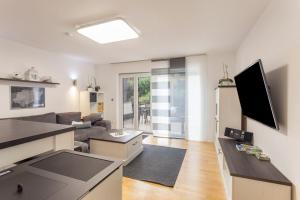 a living room with a couch and a tv at Ferienwohnung Zur Quelle in Plettenberg