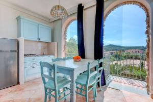 a kitchen with a table and chairs and a large window at Appartamenti Castle in Campo nell'Elba