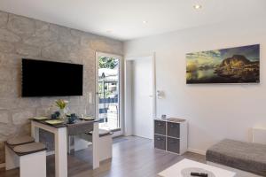a living room with a desk and a tv on a wall at Pension Haus Leni am Schwanenteich in Mühlhausen