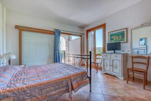 a bedroom with a bed and a tv and chairs at Appartamenti Castle in Campo nell'Elba