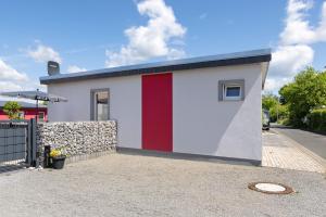 a small house with a red stripe on it at Pension Haus Leni am Schwanenteich in Mühlhausen