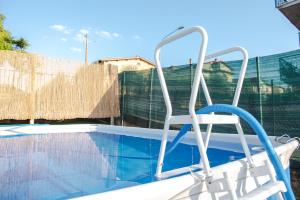 a white chair sitting next to a swimming pool at Casa Belvedere in Foiano della Chiana