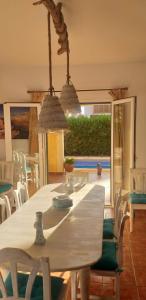 a dining room with a white table and chairs at Villa Paula in Sa Ràpita