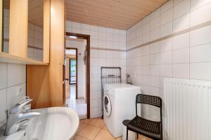 a bathroom with a sink and a washing machine at Ferienwohnung Eleonore in Meßstetten +19 photos