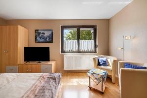 a room with a bed and a tv and a window at Ferienwohnung Eleonore in Meßstetten