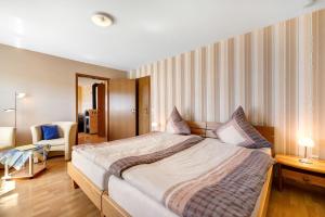 a bedroom with a large bed and a chair at Ferienwohnung Eleonore in Meßstetten
