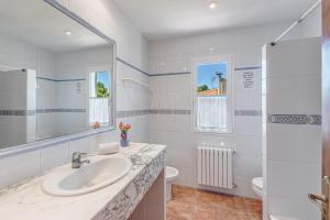 a white bathroom with a sink and a toilet at Villa Paula in Sa Ràpita +23 photos