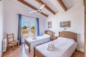 a bedroom with two beds and a balcony at Villa Paula in Sa Ràpita