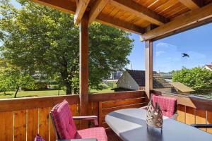 a patio with a table and chairs on a wooden deck at Ferienwohnung Eleonore in Meßstetten